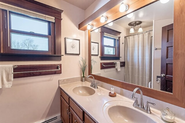 full bathroom featuring a sink, curtained shower, baseboard heating, and double vanity