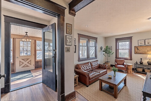 living room with wood finished floors, baseboards, and a chandelier