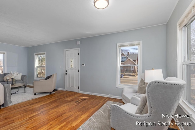 living room with a healthy amount of sunlight, baseboards, and wood finished floors