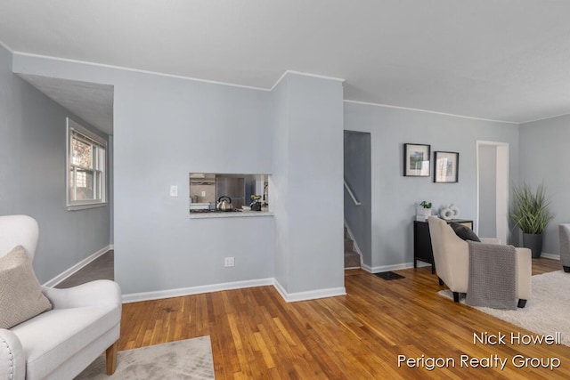 living room with crown molding, stairway, wood finished floors, and baseboards