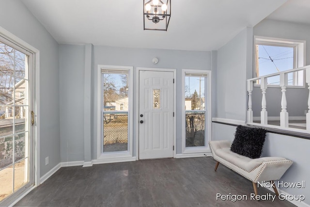 foyer with baseboards, a notable chandelier, and dark wood-style floors