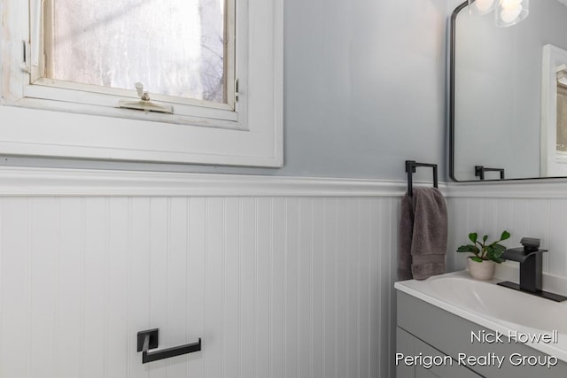 bathroom with vanity and a wainscoted wall