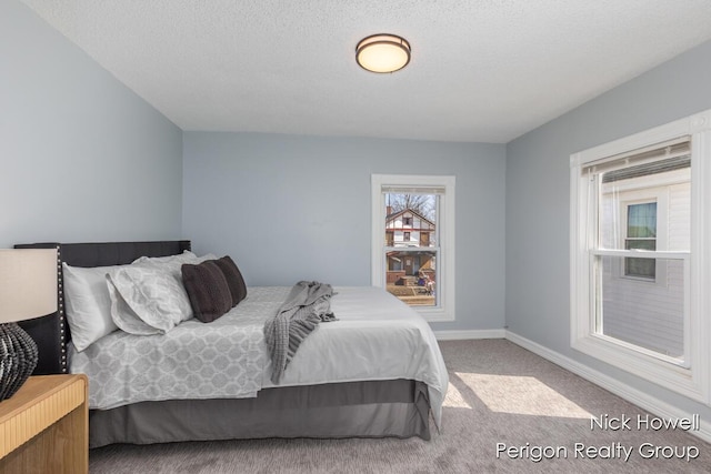 carpeted bedroom with baseboards and a textured ceiling