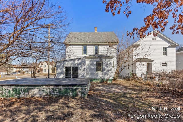 rear view of property featuring a deck and a chimney