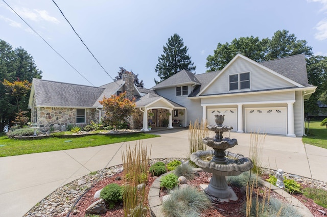 view of front facade with a garage, concrete driveway, and a shingled roof