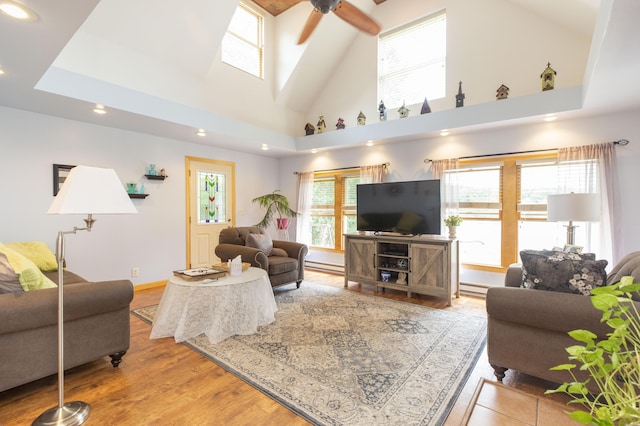 living area with recessed lighting, wood finished floors, ceiling fan, and a baseboard radiator