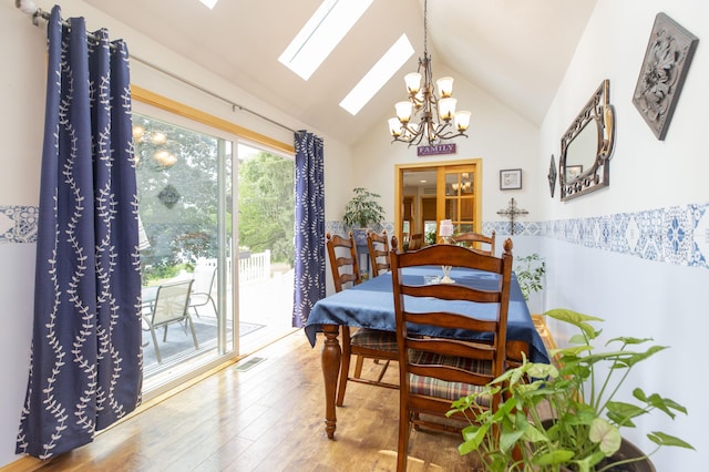 15797 Hillside Dr, Vandalia, MI 49095 - dining space featuring visible vents, vaulted ceiling with skylight, and wood finished floors