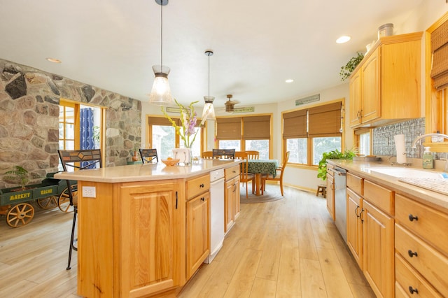 15797 Hillside Dr, Vandalia, MI 49095 - kitchen featuring a sink, light countertops, stainless steel dishwasher, light wood-type flooring, and a center island