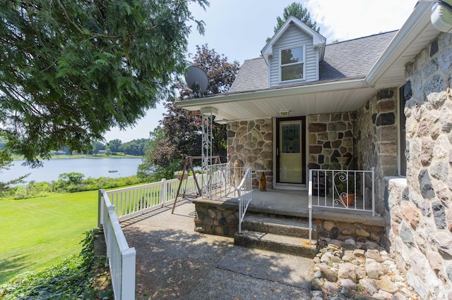 15797 Hillside Dr, Vandalia, MI 49095 - doorway to property with a water view, stone siding, a yard, covered porch, and a shingled roof