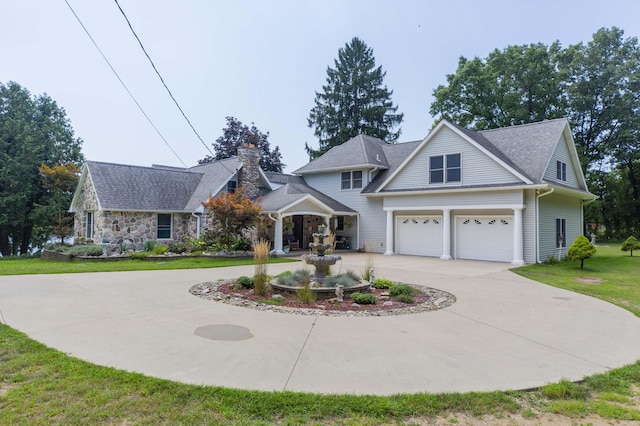 15797 Hillside Dr, Vandalia, MI 49095 - view of front of property with stone siding, curved driveway, a front yard, a garage, and a chimney