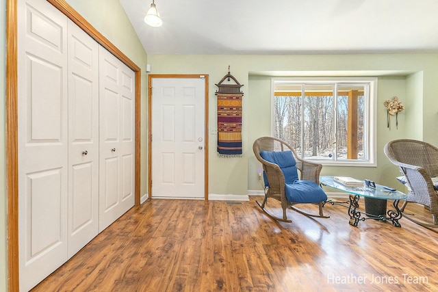 sitting room featuring lofted ceiling, wood finished floors, and baseboards