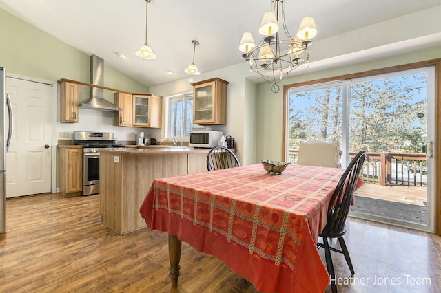 dining area featuring a notable chandelier, light wood-style flooring, and lofted ceiling