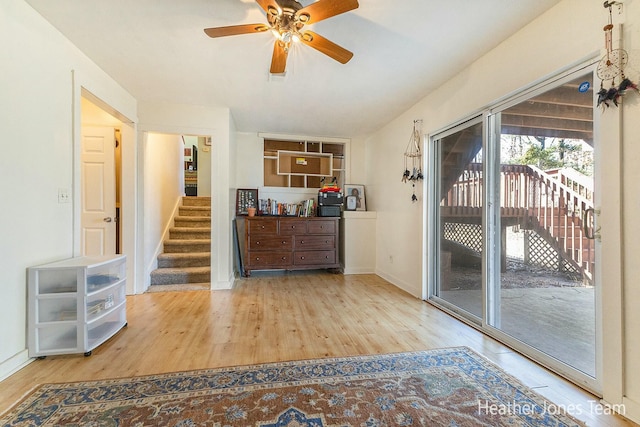 interior space with stairs, wood finished floors, baseboards, and a ceiling fan