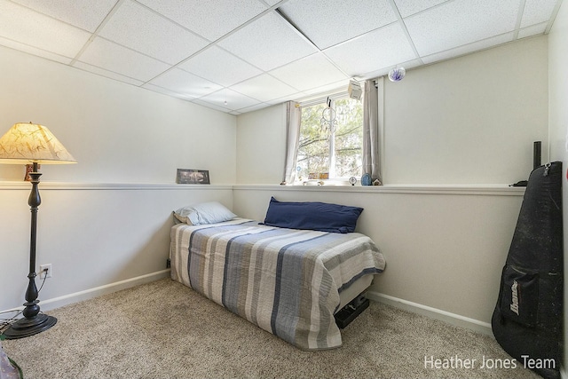 bedroom featuring carpet, baseboards, and a paneled ceiling