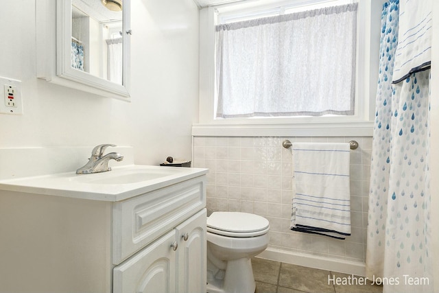 full bathroom with vanity, a shower with curtain, tile walls, toilet, and tile patterned floors