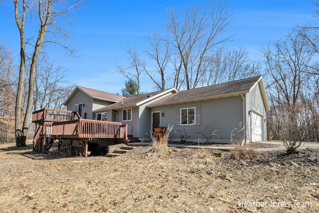 back of property featuring a deck and a garage