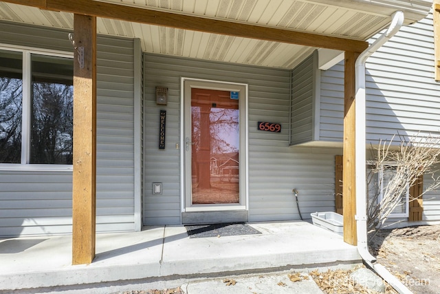 view of exterior entry featuring covered porch