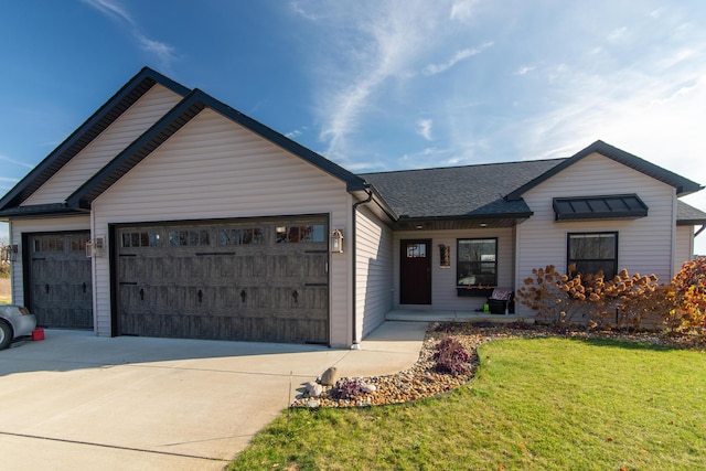 ranch-style home featuring a front yard, an attached garage, driveway, and roof with shingles