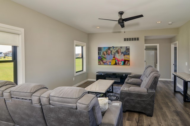 living area featuring visible vents, baseboards, and dark wood finished floors