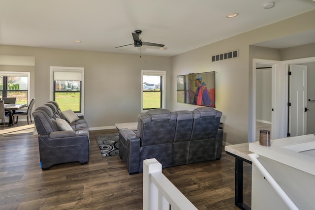 living area with dark wood-style floors, visible vents, and a healthy amount of sunlight