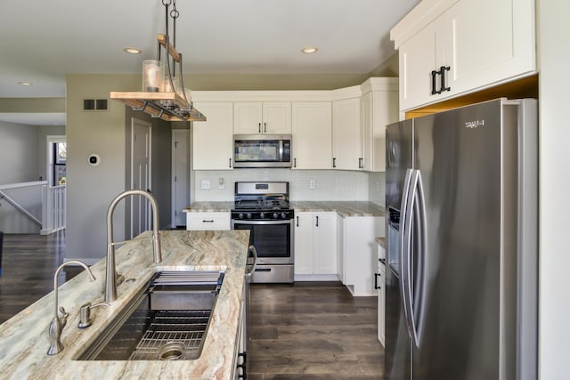 kitchen with a sink, visible vents, white cabinetry, and stainless steel appliances