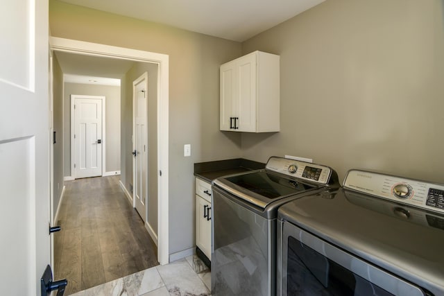 washroom featuring cabinet space, independent washer and dryer, and baseboards