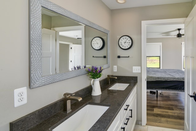 ensuite bathroom featuring ceiling fan, ensuite bath, double vanity, and a sink