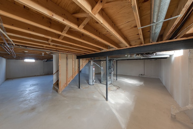 basement with gas water heater, heating unit, and stairs