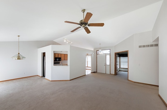 unfurnished living room with baseboards, visible vents, ceiling fan, vaulted ceiling, and light carpet