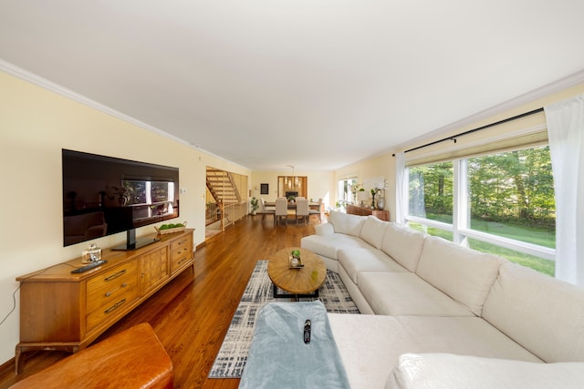 living room with stairway, wood finished floors, and ornamental molding