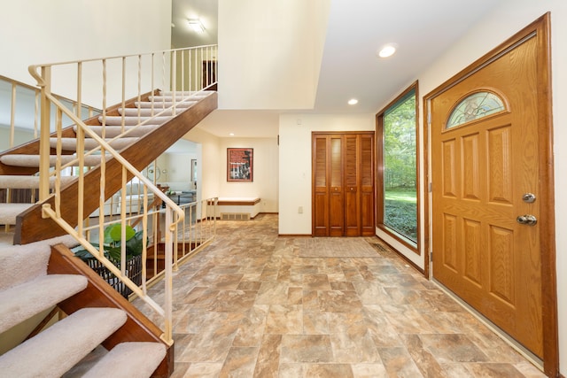 foyer with visible vents, stone finish floor, recessed lighting, stairway, and baseboards