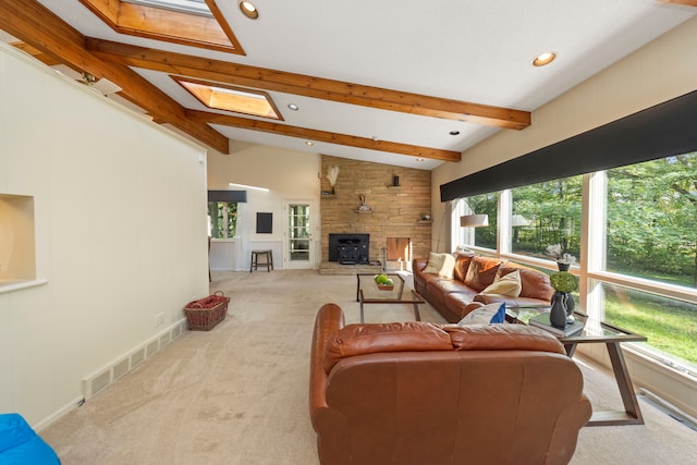 carpeted living room featuring recessed lighting, visible vents, vaulted ceiling with skylight, and baseboards