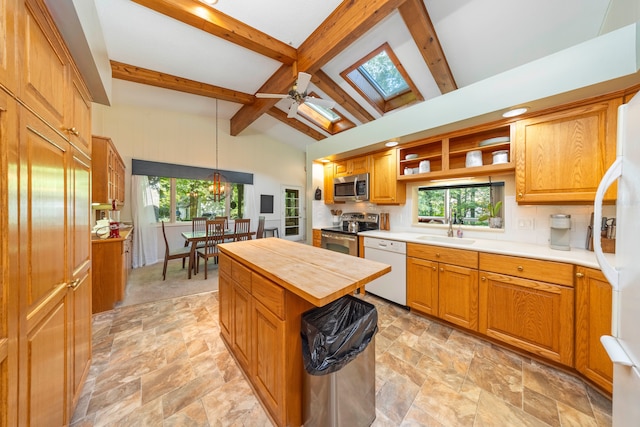 kitchen featuring a sink, decorative backsplash, stainless steel appliances, wood counters, and lofted ceiling with skylight