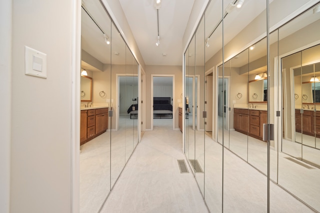 ensuite bathroom with rail lighting, visible vents, two vanities, and ensuite bathroom