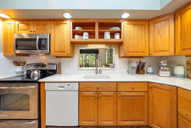 kitchen featuring open shelves, stainless steel appliances, light countertops, and a sink