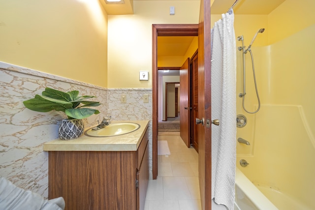 bathroom with a wainscoted wall, shower / bath combo, tile walls, tile patterned flooring, and vanity