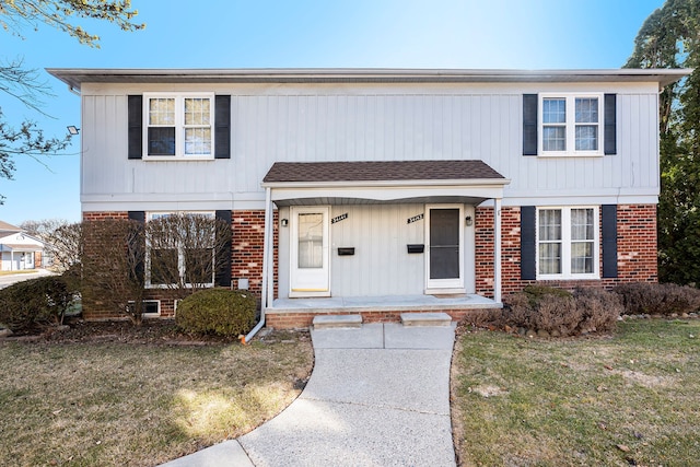 view of front of home featuring brick siding, a porch, and a front lawn