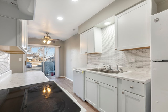 kitchen with tasteful backsplash, white cabinets, white appliances, a ceiling fan, and a sink