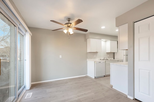 kitchen with a ceiling fan, tasteful backsplash, white appliances, light countertops, and baseboards