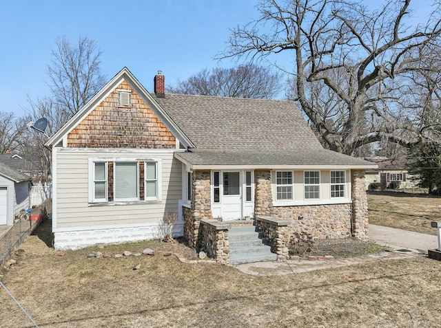 view of front of home with stone siding, a chimney, and a shingled roof