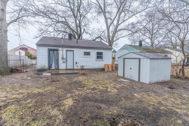 back of property with an outdoor structure, a storage unit, and fence