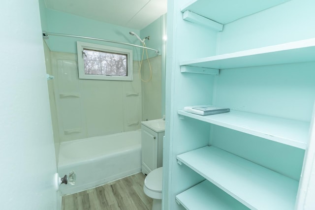 bathroom featuring vanity, toilet, wood finished floors, and shower / bathtub combination