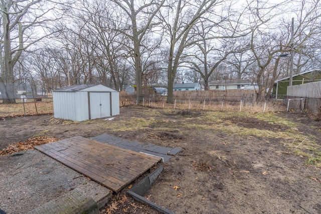 view of yard with a storage shed, a fenced backyard, and an outdoor structure