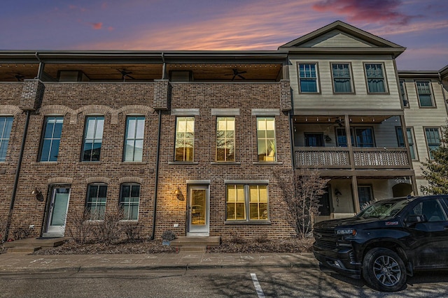 multi unit property featuring brick siding and ceiling fan