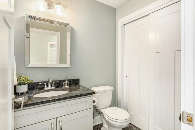 half bathroom featuring toilet and vanity