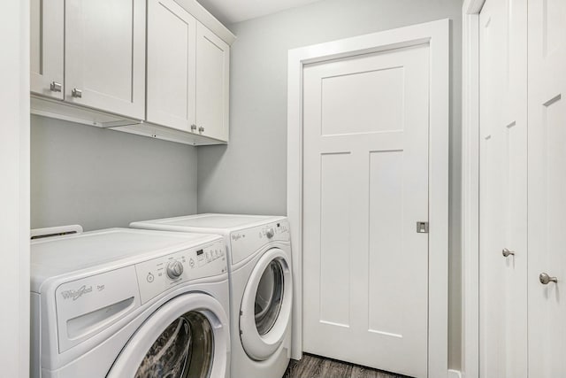 laundry area with dark wood-style floors, washing machine and dryer, and cabinet space