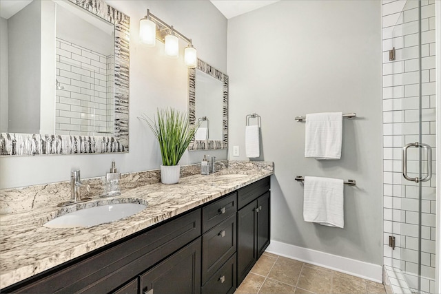 bathroom with a sink, baseboards, double vanity, and a shower stall