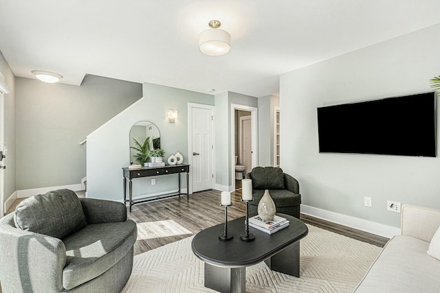 living area featuring stairs, wood finished floors, and baseboards