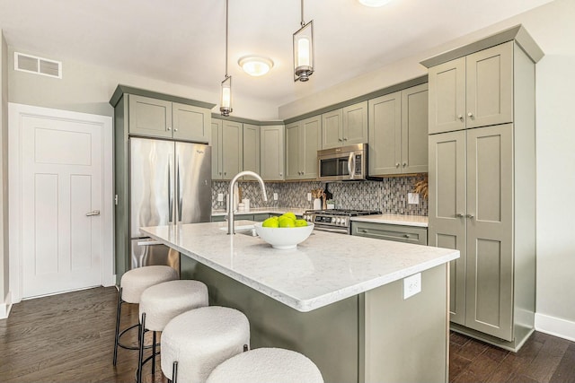 kitchen with visible vents, dark wood finished floors, gray cabinets, appliances with stainless steel finishes, and tasteful backsplash