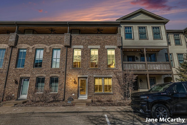 multi unit property with a ceiling fan and brick siding